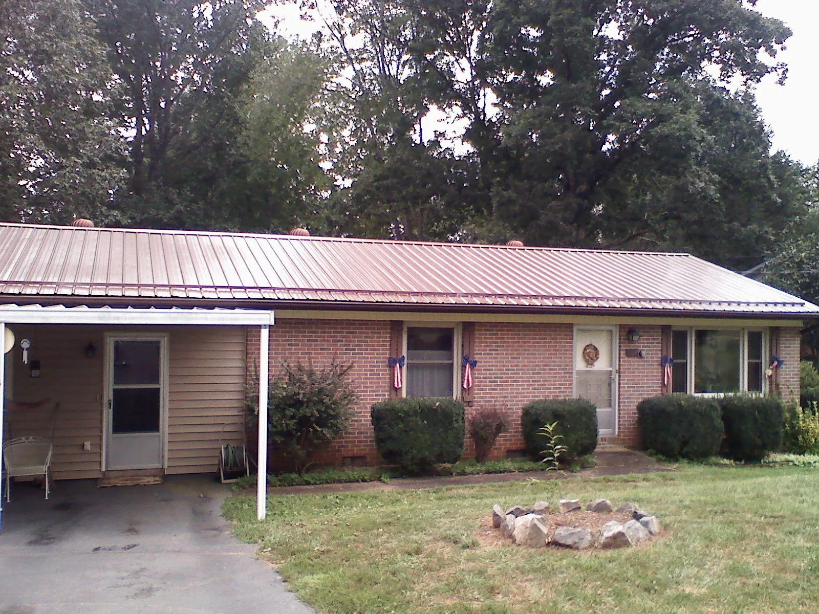 Bronze metal roof and carport on a brick ranch home — Roof Repair work by our crew in Mastic